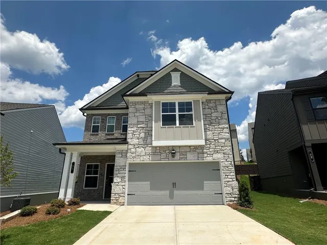 Two-story residence featuring a stone facade and a two-car garage