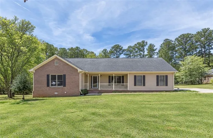 Ranch-style residence featuring brick and siding exterior, a covered front porch with white railings, and a dark shingle roof