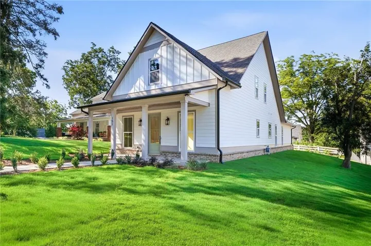 Modern farmhouse exterior with white siding, a prominent gable, and a covered porch