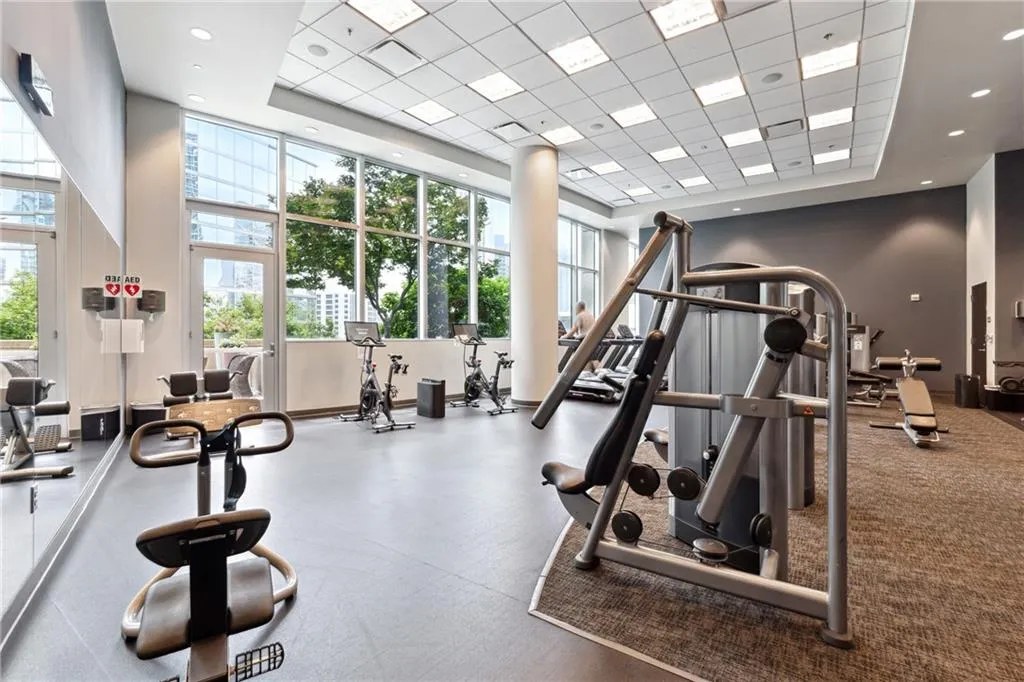 Gym featuring a towering ceiling and a drop ceiling