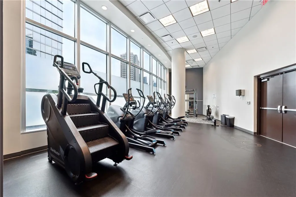 Gym with a towering ceiling and a paneled ceiling