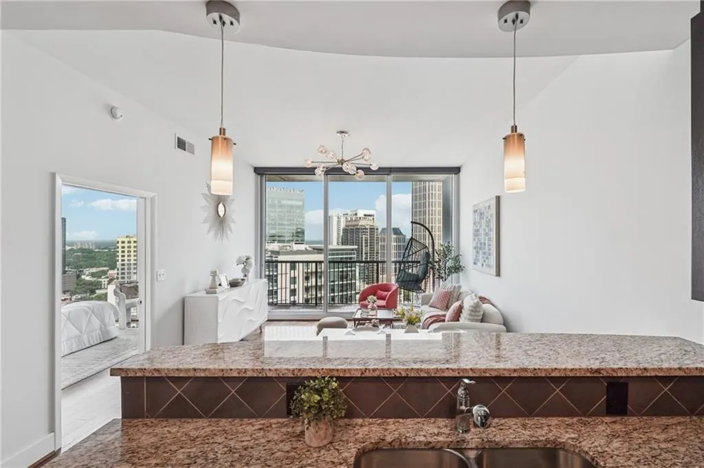 Kitchen with plenty of natural light, a chandelier, a city view, and light stone countertops