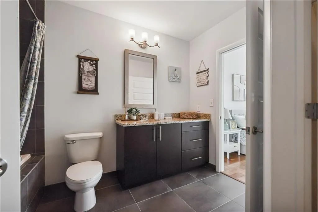 Full bath featuring toilet, vanity, tile patterned floors, and shower / bathtub combination with curtain