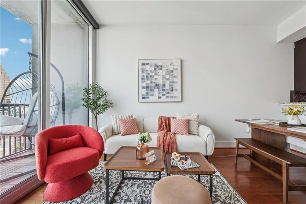 Living area with plenty of natural light, wood finished floors, and baseboards