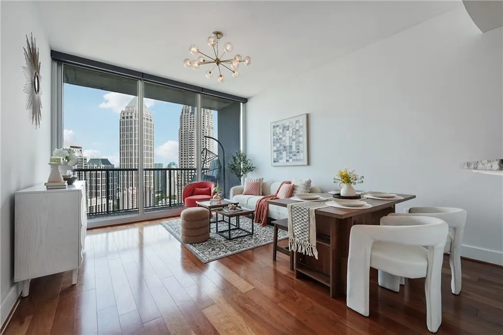 Dining room featuring a chandelier, wood finished floors, expansive windows, a city view, and baseboards