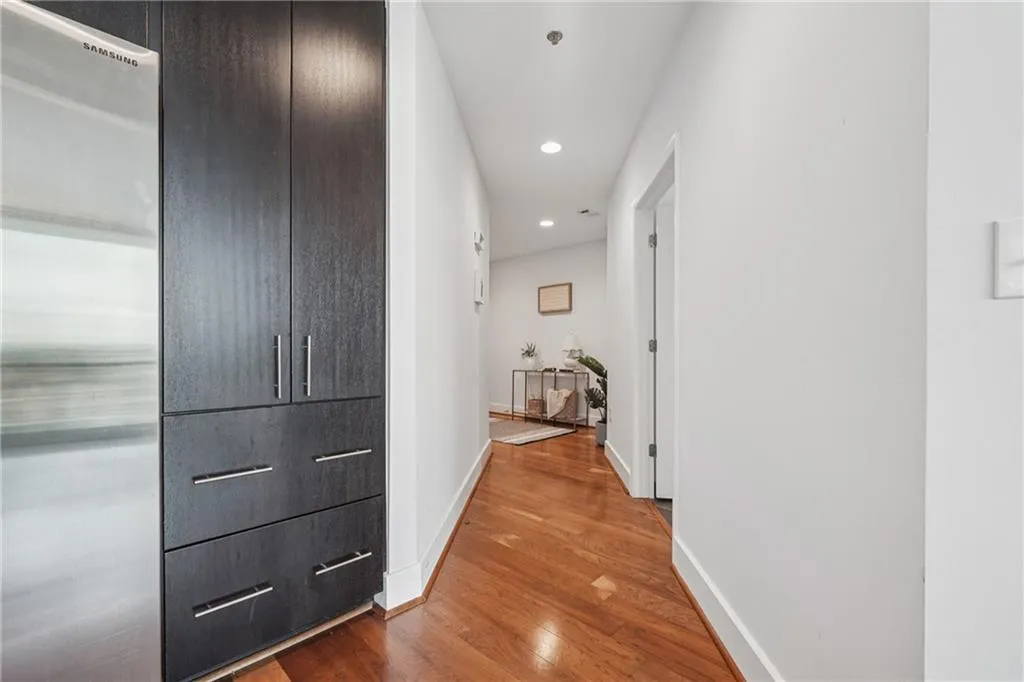 Hallway with wood finished floors, baseboards, and recessed lighting