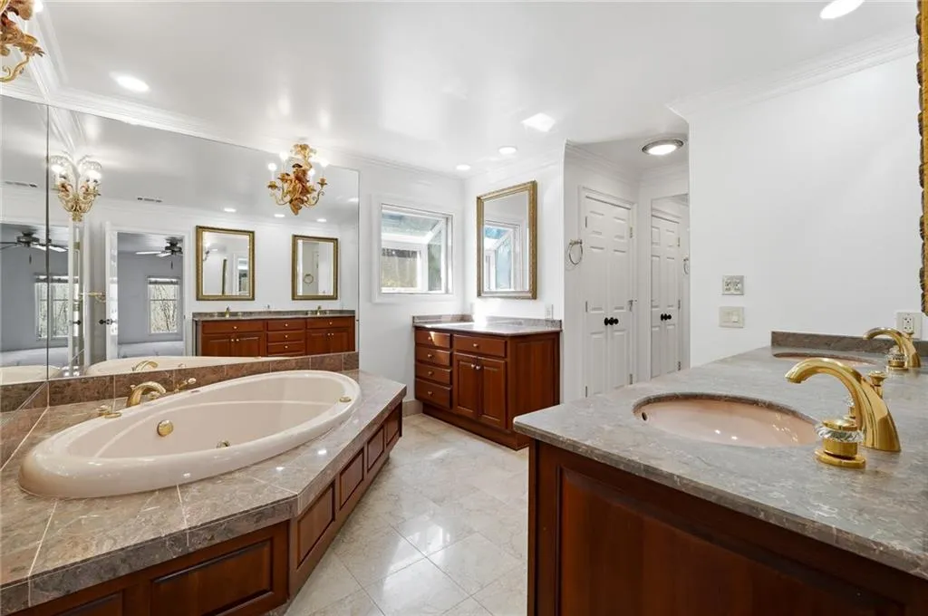 The Master Bathroom is spacious and functional with it's dual vanity sinks and extra getting ready area. Mirrors line the wall behind the jacuzzi making the space look large and luxury.