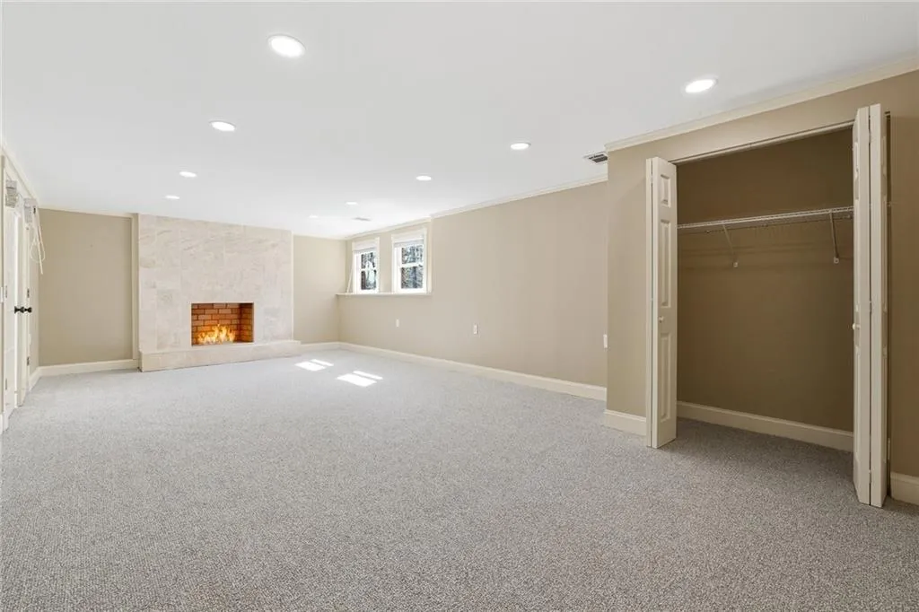 Downstairs in the basement - this room could be used as a bedroom with a closet and bathroom, guest quarters or as additional living space. Complete with new carpet, a fireplace and windows.