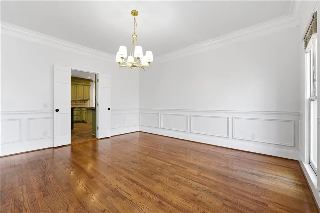 The formal dining room has gorgeous hardwood floors, paneling, new designer light fixture and lots of light.