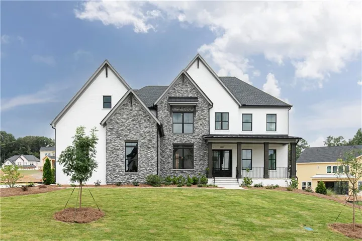 Two-story residence featuring white siding and gray stone veneer