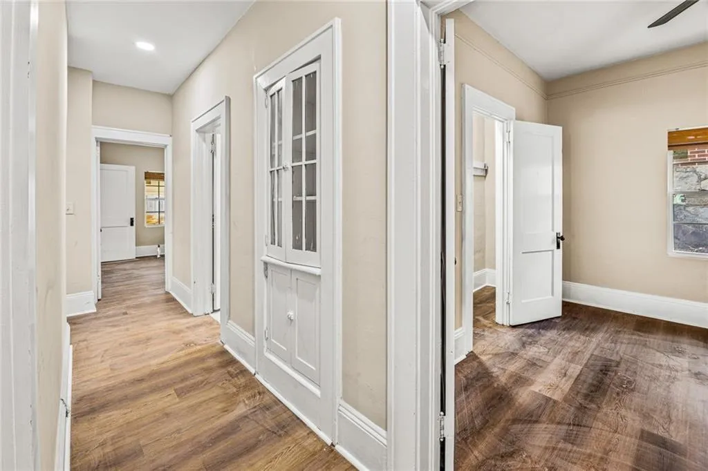 Hallway featuring dark wood finished floors and baseboards