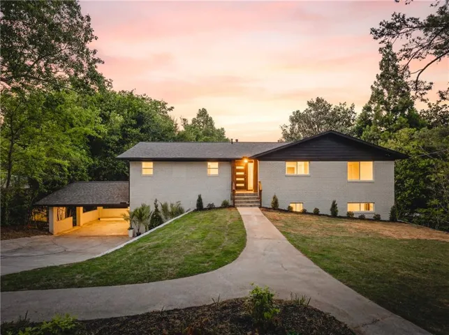 Split-level residence featuring a brick exterior and a covered carport