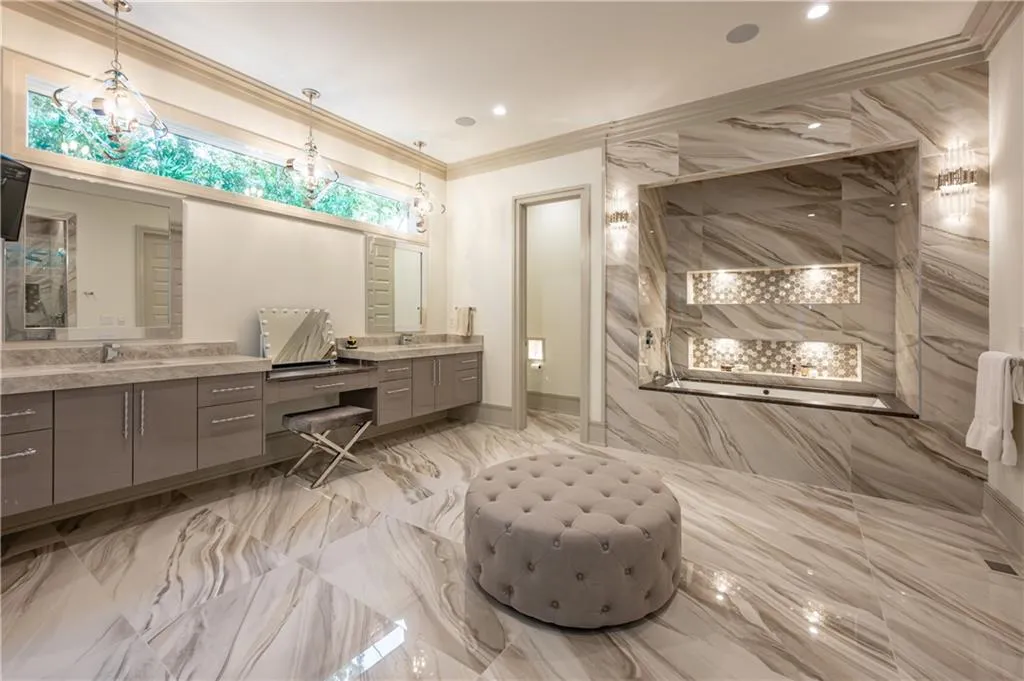 Expansive bathroom with soaking tub, his and her water closets, and a dual vanity with a makeup station