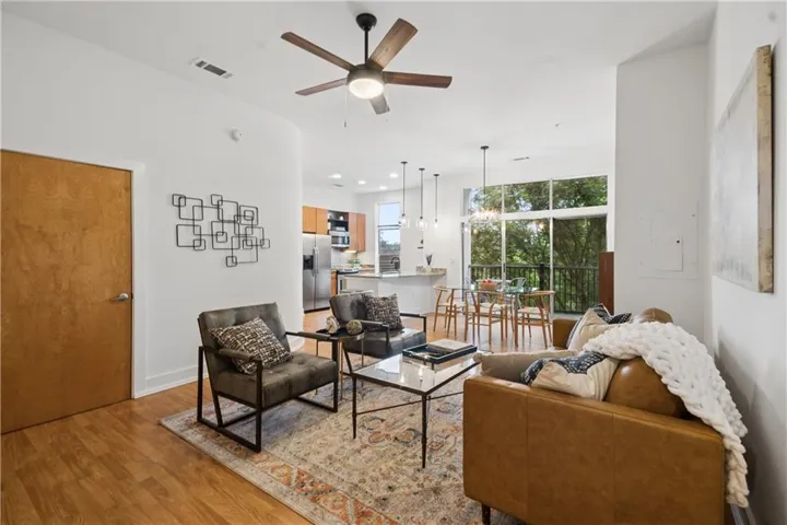 Open-concept living space featuring wood-finish flooring, a contemporary ceiling fan, and recessed lighting