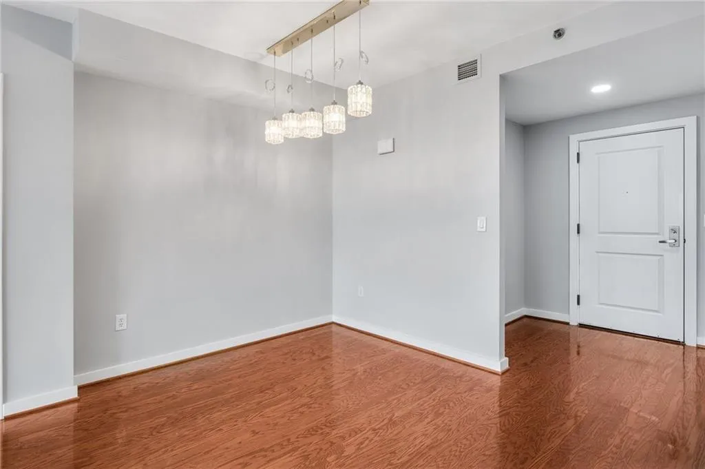 Spare room with wood finished floors, a chandelier, and recessed lighting
