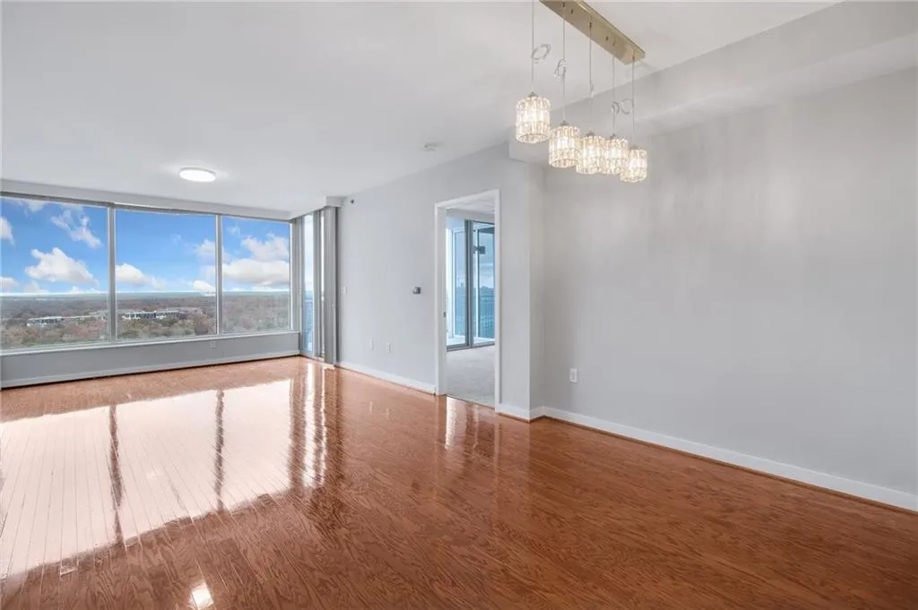 Unfurnished room with wood finished floors and a chandelier
