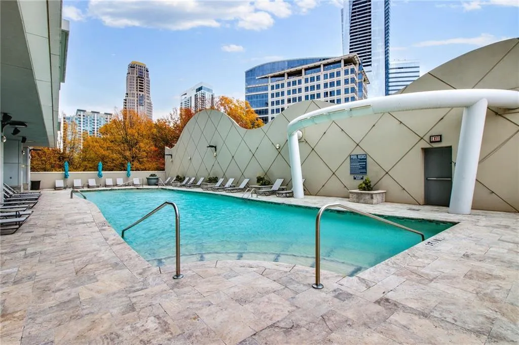 Community pool with a patio area and a city view