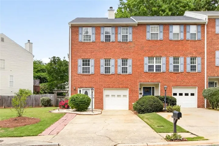 Brick exterior with a dark shingle roof and light blue window shutters