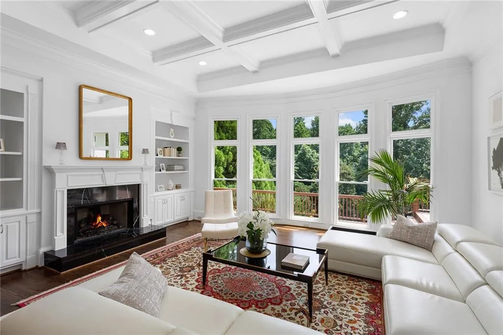 Living room with beamed ceiling, coffered ceiling, crown molding, and dark hardwood / wood-style floors