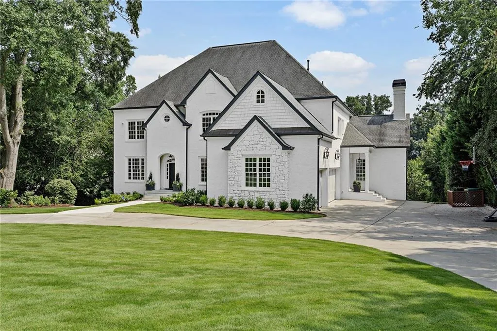 French country inspired facade featuring a garage and a front yard