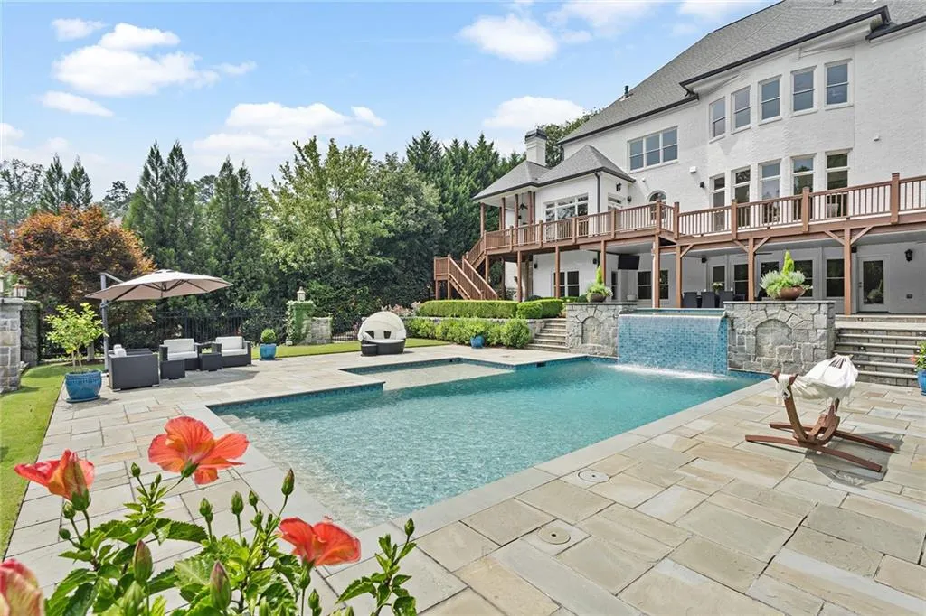 View of swimming pool featuring a wooden deck, pool water feature, a patio area, and outdoor lounge area