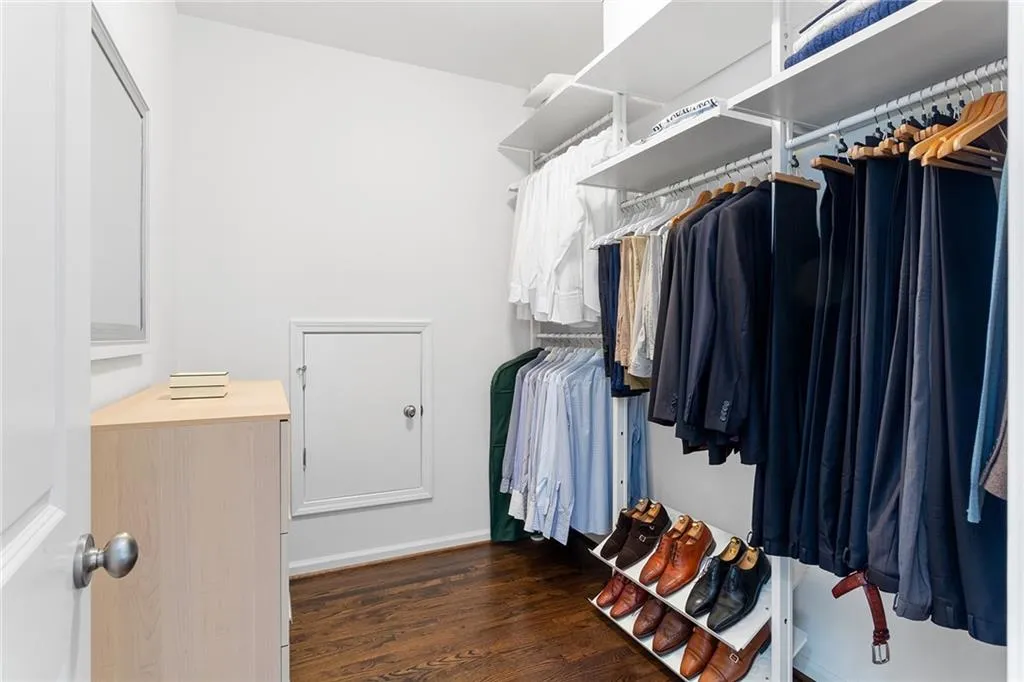 Walk in closet with dark wood-type flooring