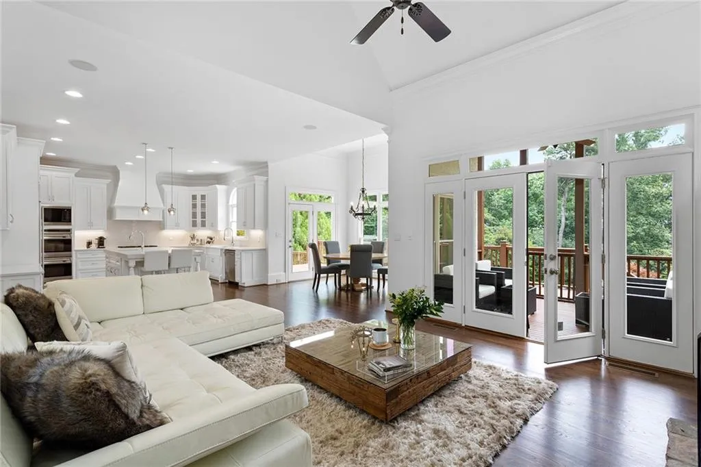 Living room featuring sink, plenty of natural light, ceiling fan with notable chandelier, and dark hardwood / wood-style floors