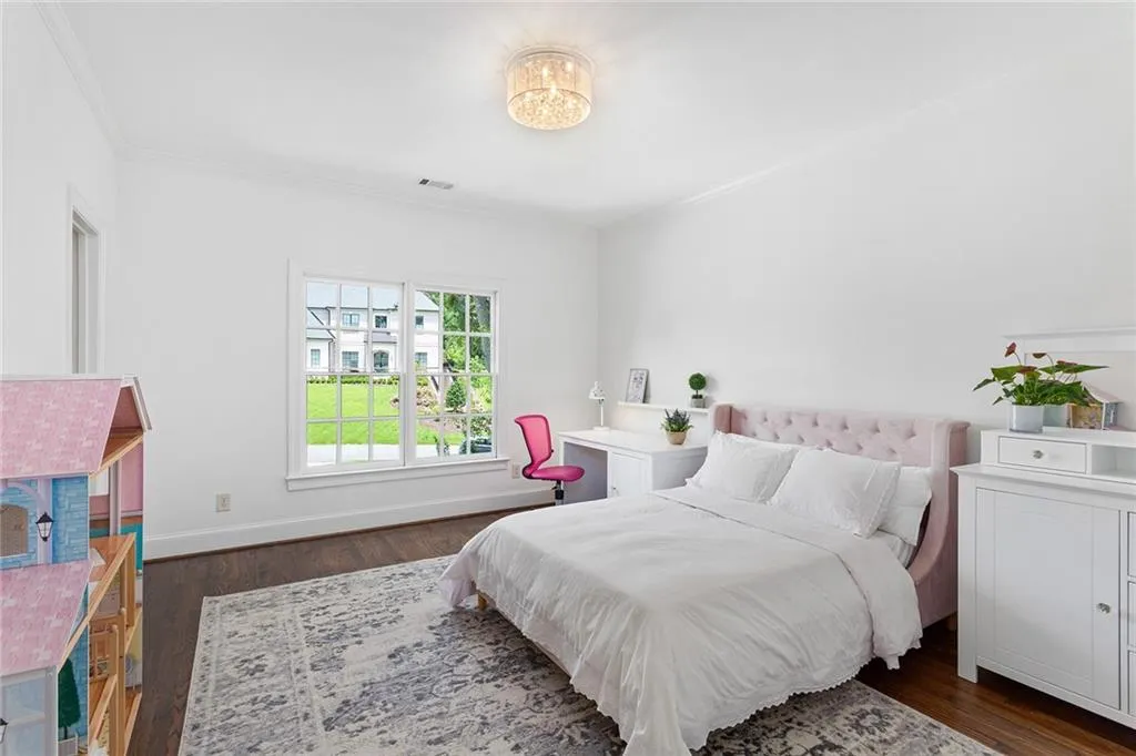 Bedroom with dark hardwood / wood-style flooring and crown molding