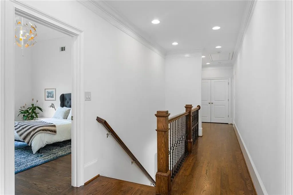 Corridor featuring dark hardwood / wood-style flooring, a chandelier, and ornamental molding
