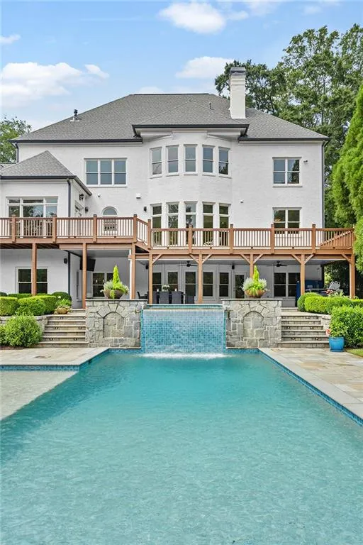 View of swimming pool with pool water feature and a wooden deck