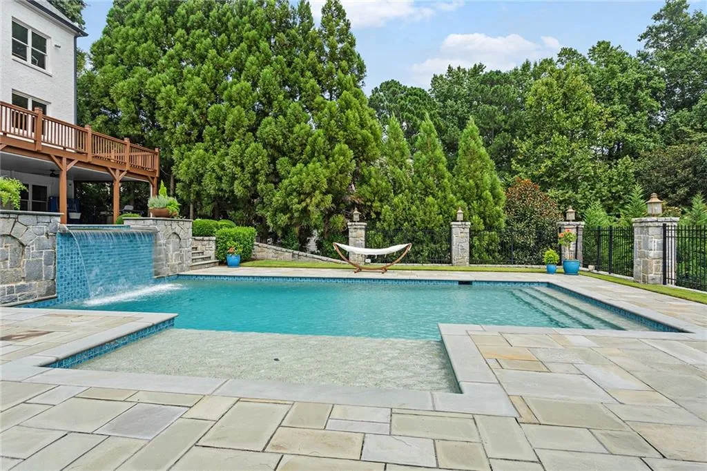 View of swimming pool featuring a patio, pool water feature, and a wooden deck