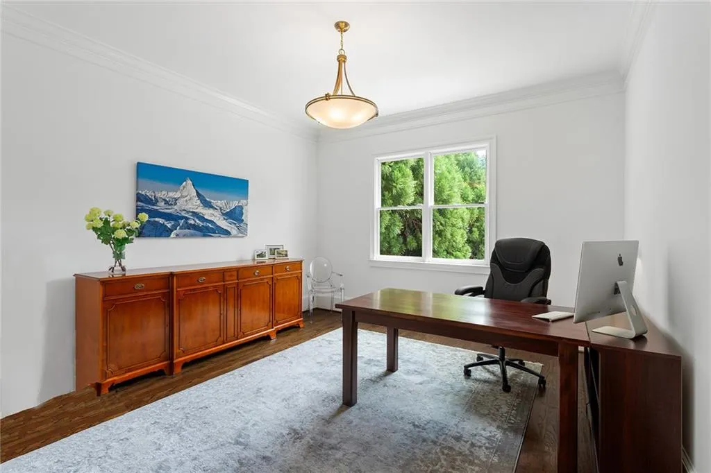Office area featuring crown molding and dark hardwood / wood-style flooring