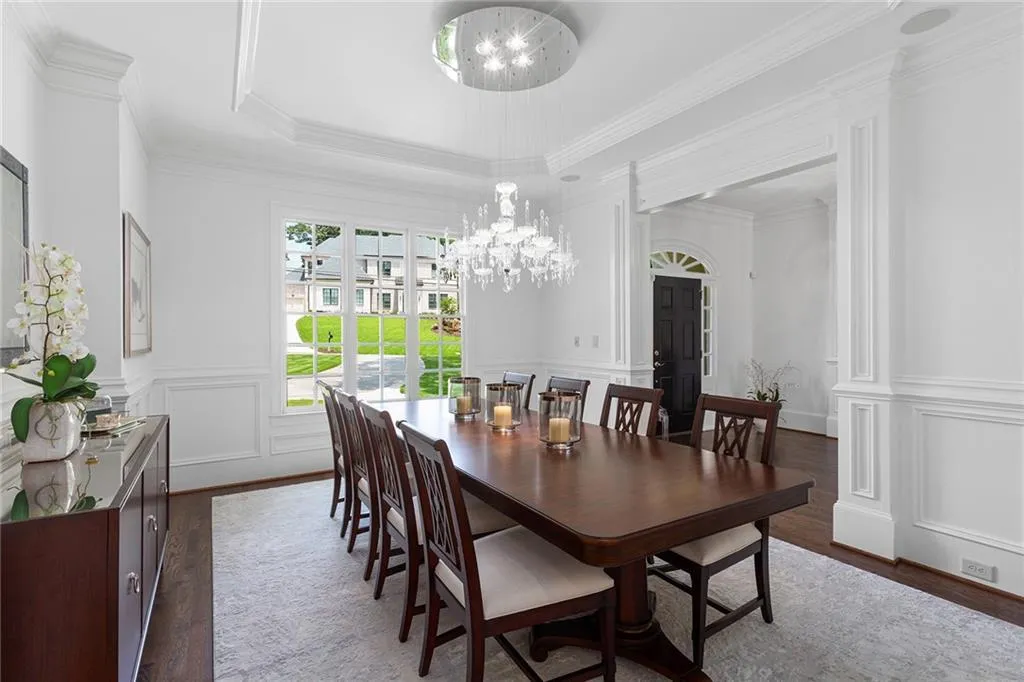 Dining space featuring a tray ceiling, crown molding, a notable chandelier, and dark hardwood / wood-style flooring