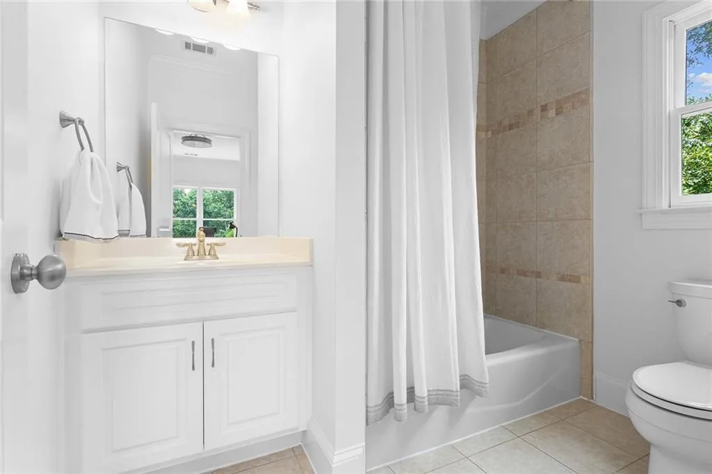 Full bathroom featuring crown molding, shower / bath combination with curtain, tile flooring, vanity, and toilet
