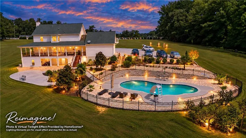 Expansive property featuring a multi-level residence with a covered porch and patio, a substantial swimming pool with a perimeter fence, and extensive landscaping