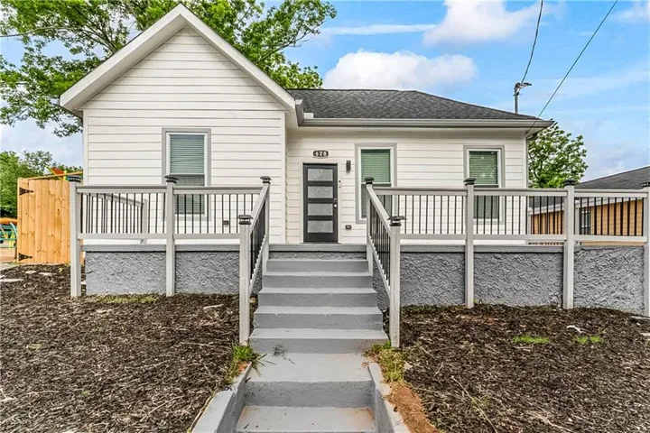 View of front of property with a wooden deck and roof with shingles