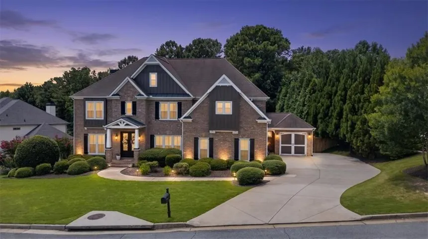 Elegant two-story brick residence with architectural detail and multiple illuminated windows