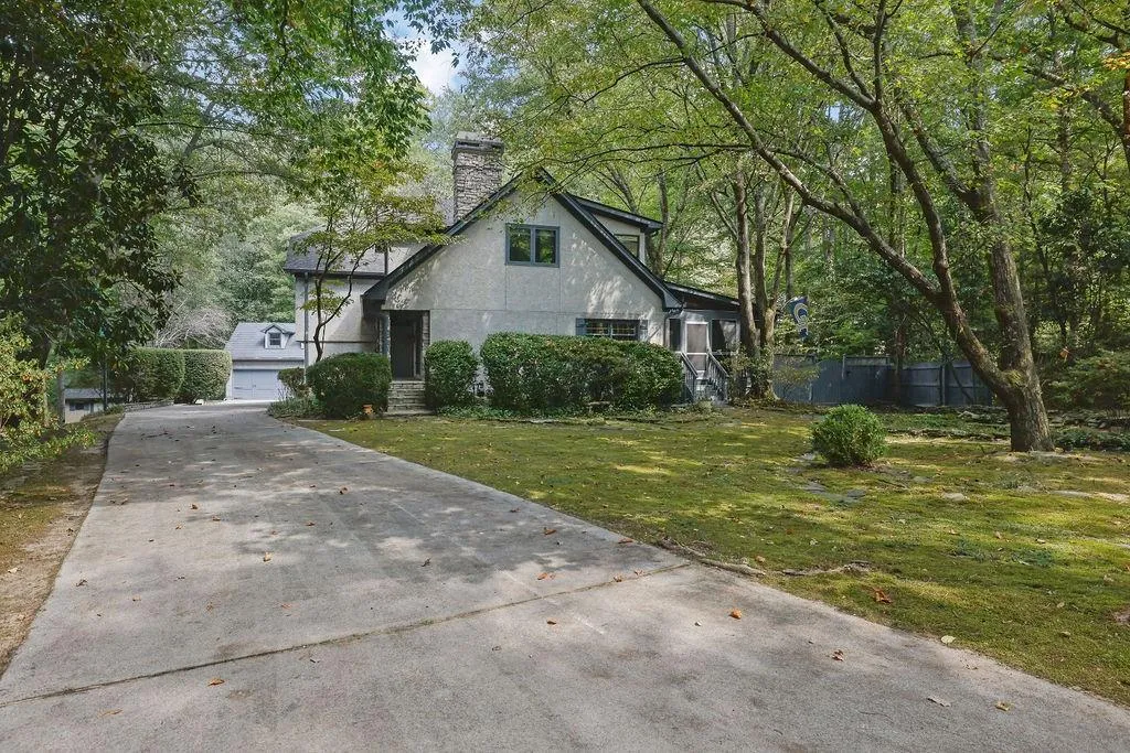 English style home featuring a garage and a front lawn