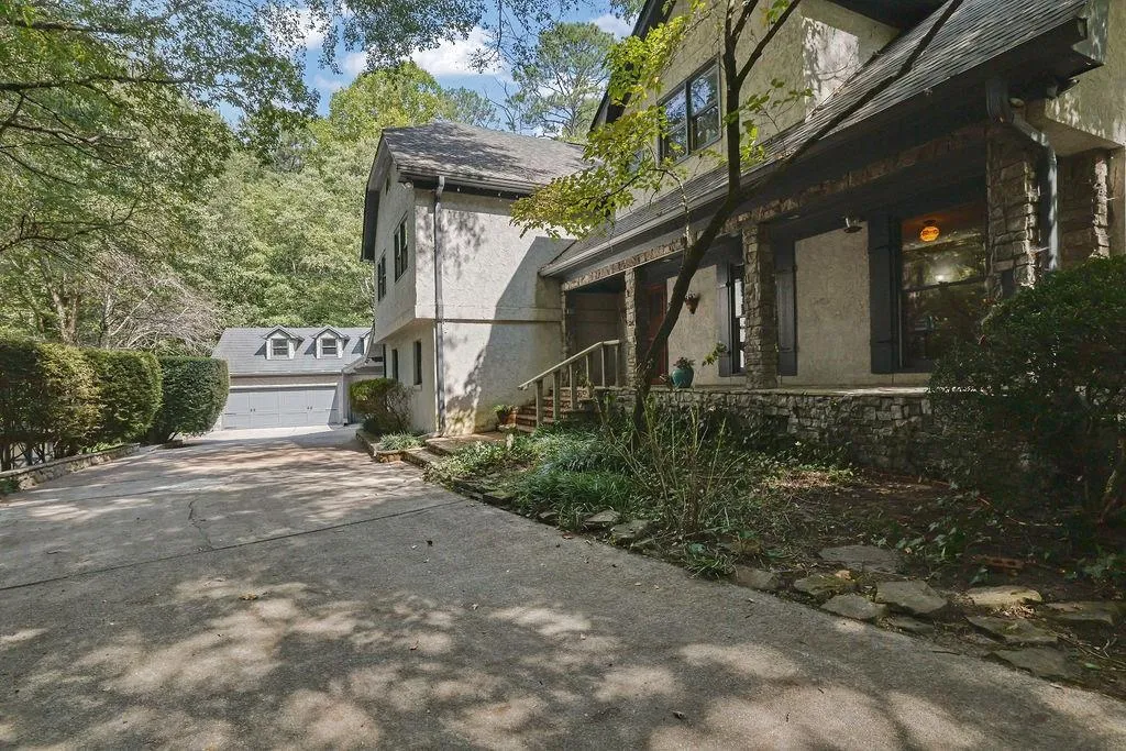 View of side of home featuring a porch and a garage