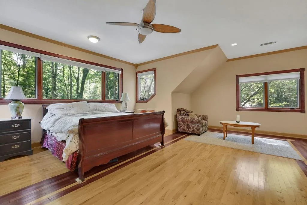 Bedroom with ceiling fan, hardwood / wood-style flooring, and crown molding