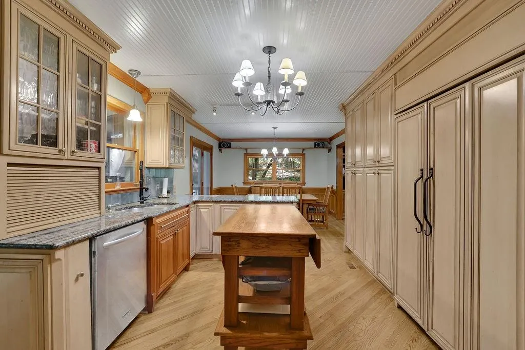 Kitchen featuring an inviting chandelier, dishwasher, hanging light fixtures, and light hardwood / wood-style floors