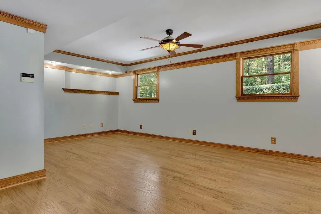 Spare room featuring ornamental molding, light wood-type flooring, and ceiling fan