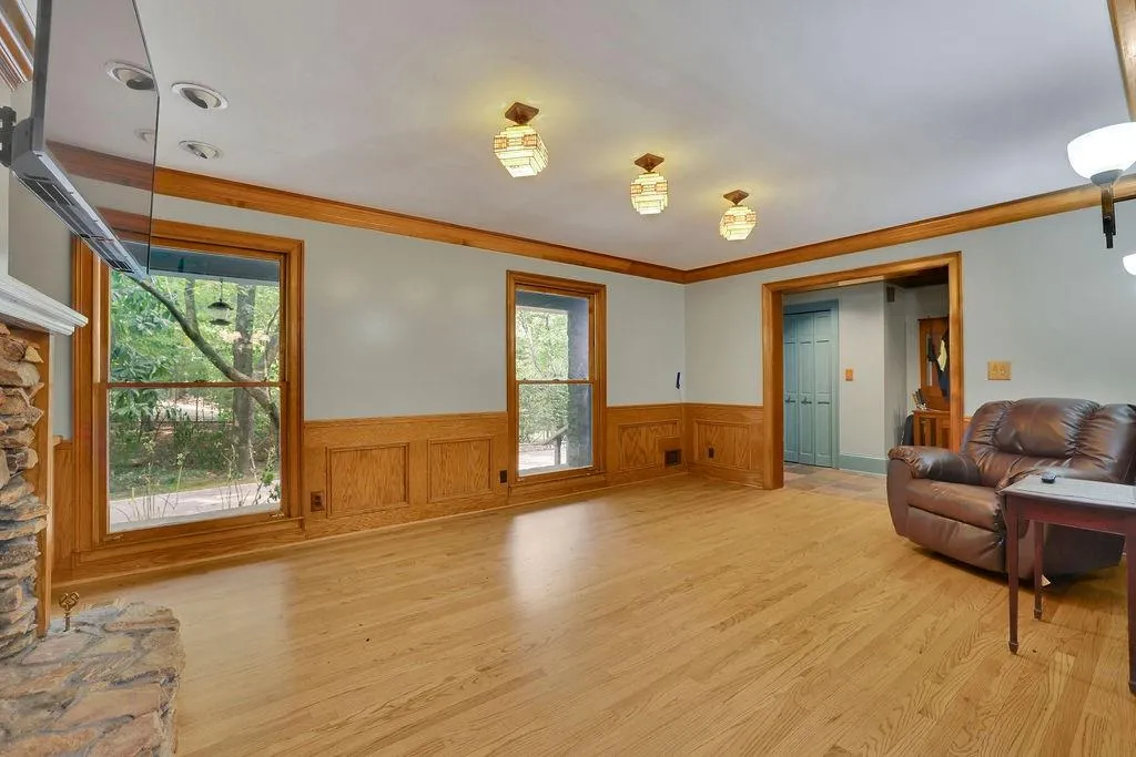 Living room featuring light hardwood / wood-style flooring, ornamental molding, a fireplace, and a healthy amount of sunlight