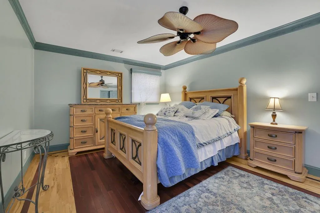 Bedroom featuring ornamental molding, dark hardwood / wood-style floors, and ceiling fan