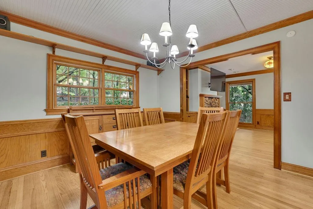 Dining area featuring a notable chandelier, wood walls, light hardwood / wood-style floors, and plenty of natural light