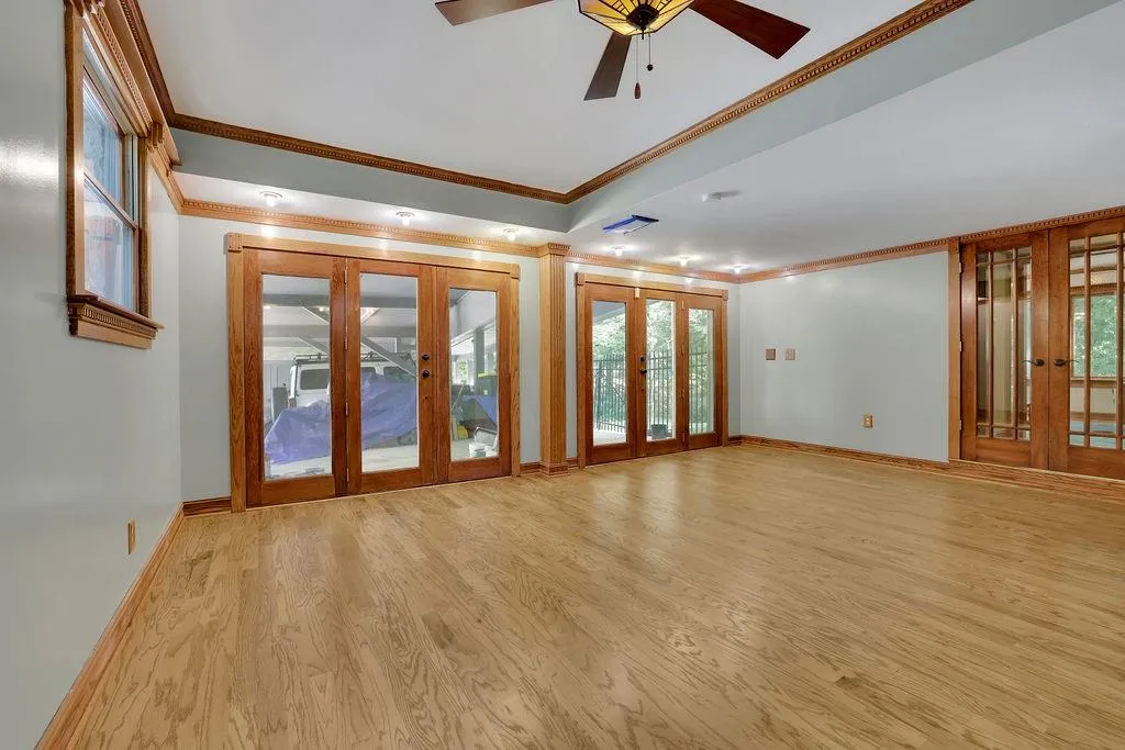 Empty room with ornamental molding, ceiling fan, light hardwood / wood-style flooring, and french doors