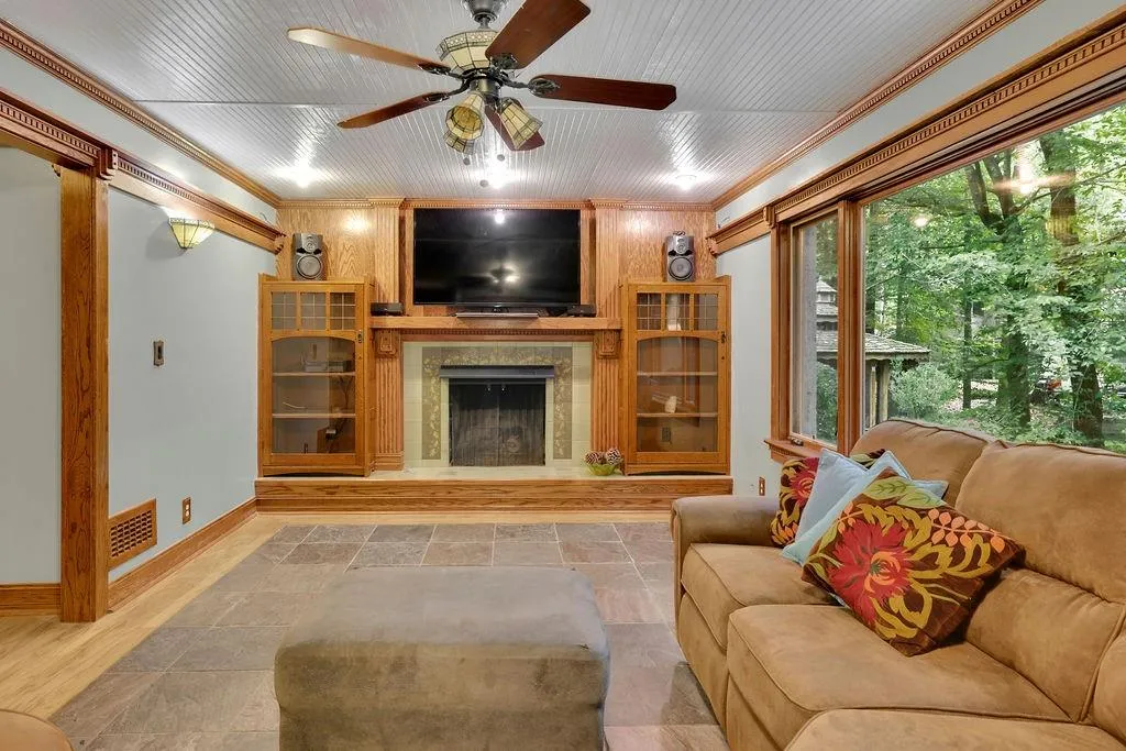 Living room with ceiling fan, hardwood / wood-style flooring, a fireplace, and crown molding