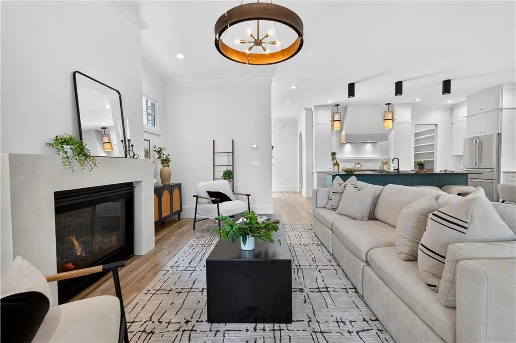 Living area featuring a fireplace, wood-finish flooring, and a decorative ceiling fixture