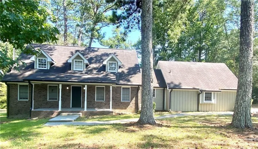 Cape cod house with covered porch and a front lawn