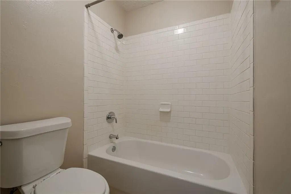Full bath with  shower combination and a textured wall